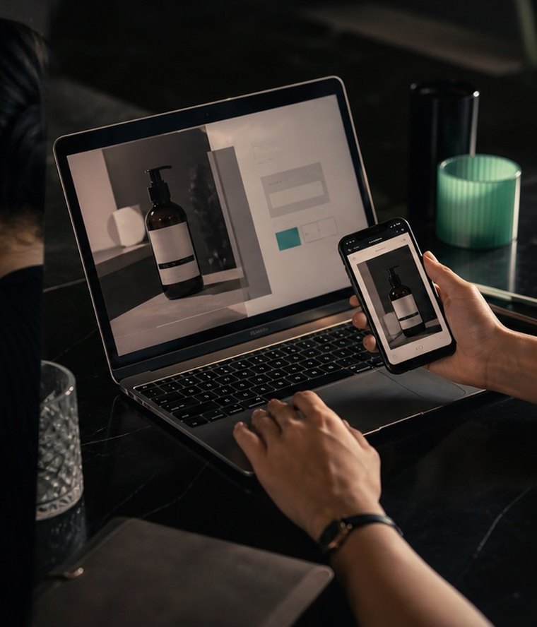 A shopper compares a product on a laptop and phone
